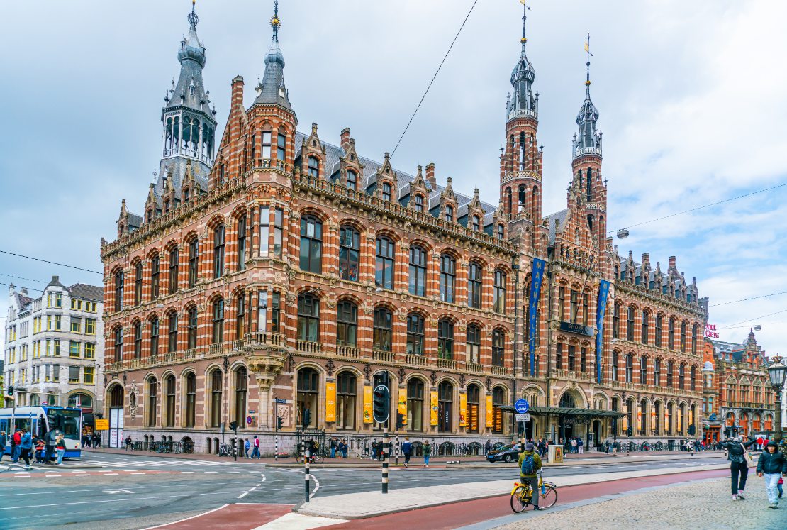 Turist som passerer det tidligere postkontoret, nå kjøpesenteret Magna Plaza, i sentrum av Amsterdam.