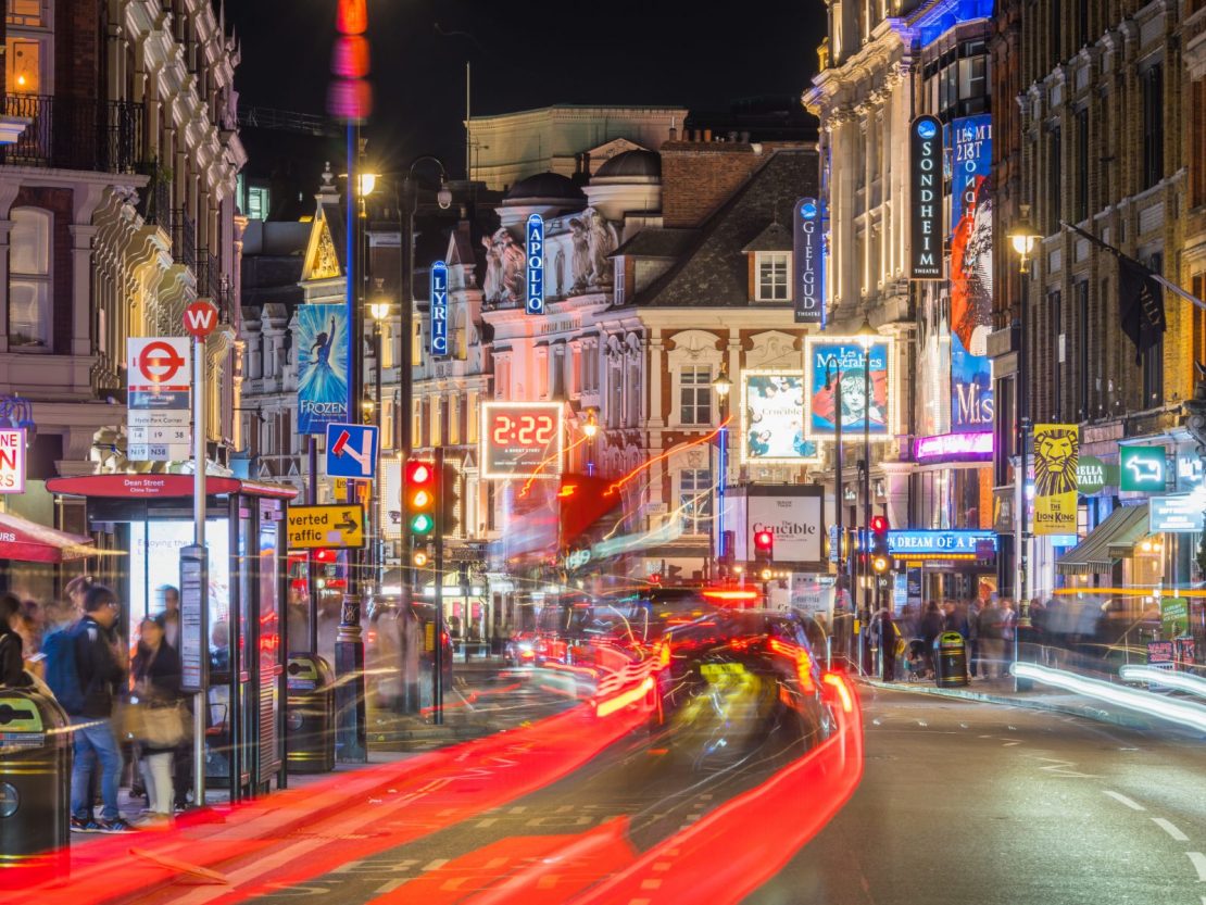 Trafikk i fart langs Shaftesbury Avenue i Londons West End Theatreland om natten.