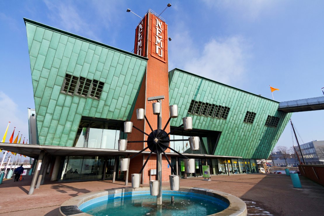 NEMO Science Center ved elven IJ nær Amsterdam sentralstasjon, kjent som Nederlands største vitenskapssenter med en arkitektur som ligner baugen på et skip.