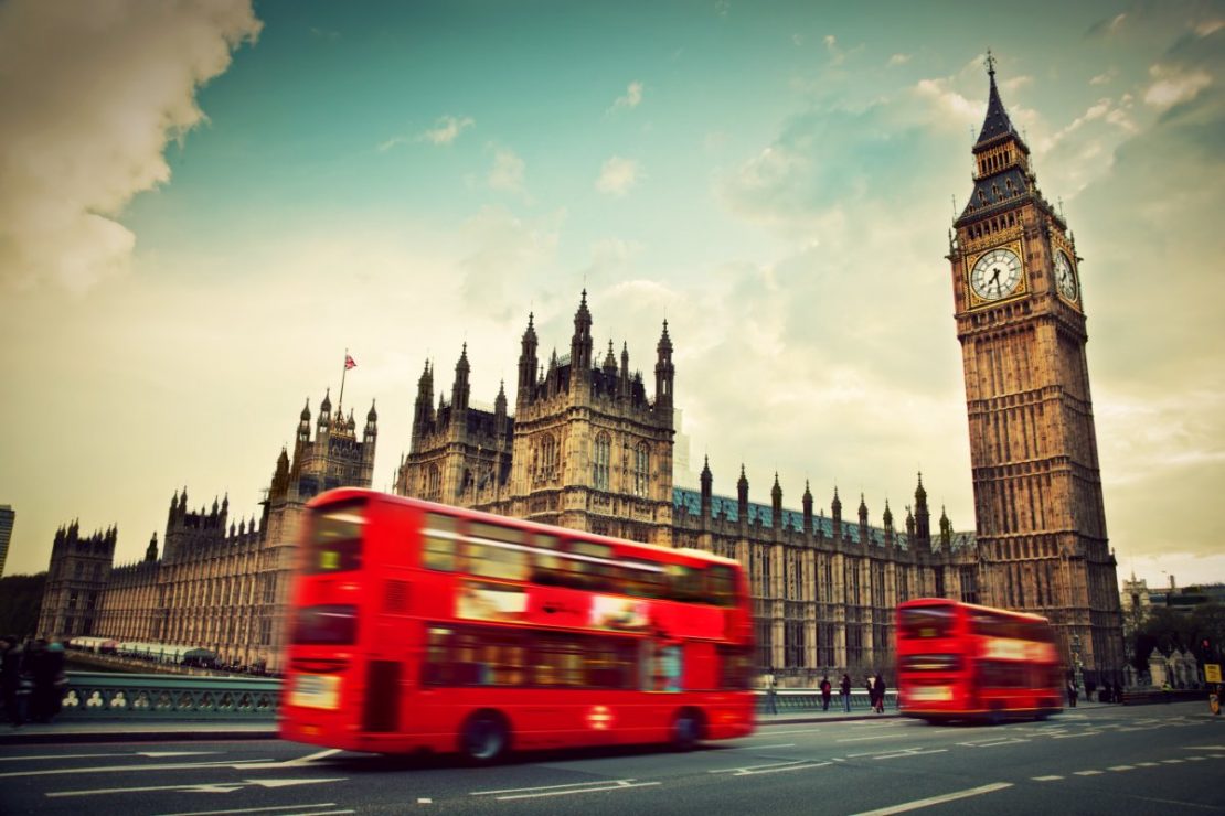 London, Storbritannia: Rød buss i bevegelse foran Big Ben og Palace of Westminster.