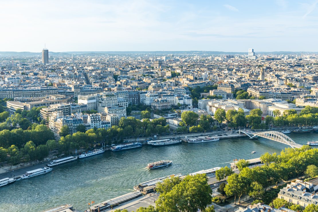 Båt som cruiser på Seinen ved gangbroen Passerelle Debilly i Paris.