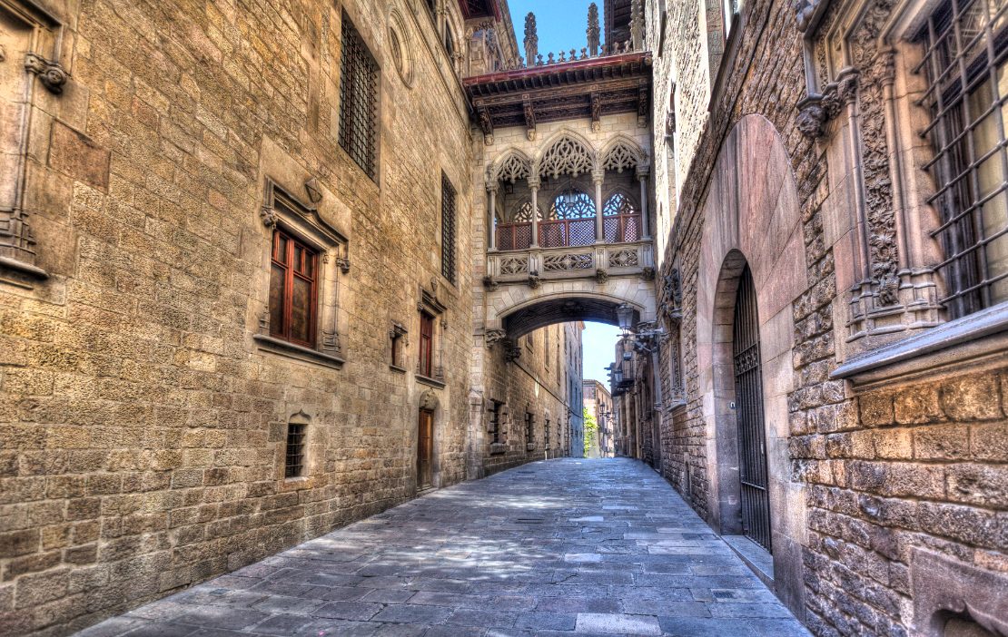 Bro i flamboyant stil mellom bygninger i Carrer del Bisbe i Barcelonas gotiske kvarter.